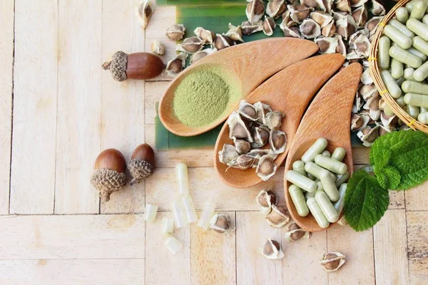 Capsula Moringa per la salute su fondo legno — Foto Stock