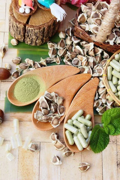 Ahşap arka plan üzerinde sağlık için Moringa kapsül
