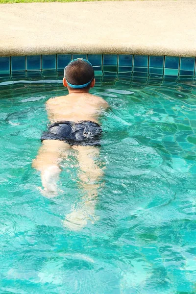 Der Junge schwimmt im Pool — Stockfoto