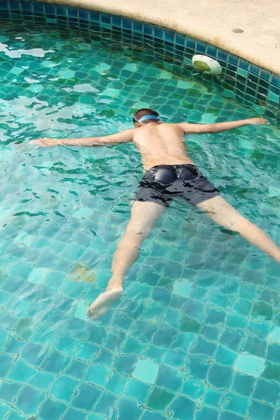 那男孩正在游泳池里游泳 — 图库照片
