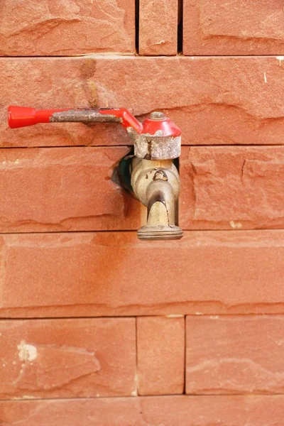 Wasserhahn auf Backsteinwand Hintergrund — Stockfoto