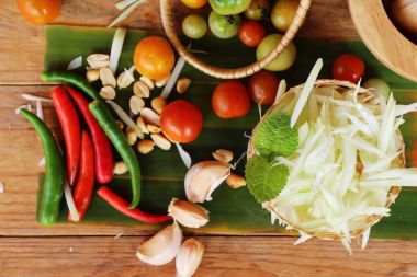 Ahşap arka plan üzerinde baharatlı papaya salatası yapmak