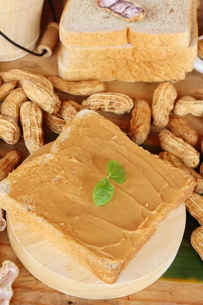 Manteiga de amendoim cremosa manchada em pão delicioso — Fotografia de Stock