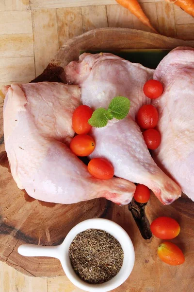 Fresh chicken legs for cooking on wood background