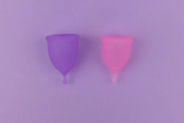 Duas xícara menstrual com tamanho diferente no fundo violeta pastel. Produto de higiene feminino alternativo durante o período. Menstruação, proteção, flat lay, espaço de cópia, vista superior — Fotografia de Stock