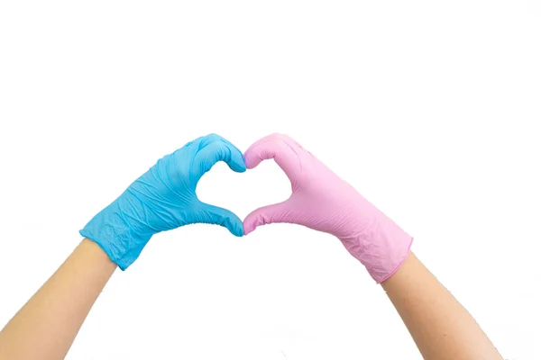 Doktorlar mavi ve pembe eldivenlerle kalp şeklini beyaza izole ediyorlar. Kadınların el hareketi ya da işareti. Virüs koruması, aşk hijyen konsepti.