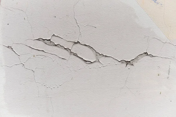 Boya deseni, duvarın dikey dokusunda çizikler ve çatlaklarla alçıya alınır. Beton yüzeyinde çizik var. Arkaplan için çürümüş pürüzün soyutlaması.