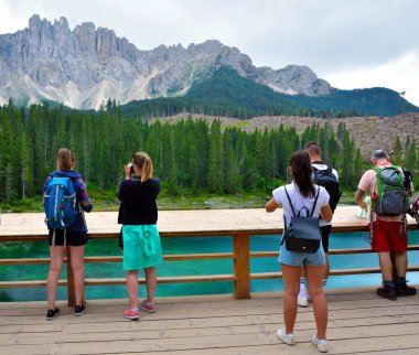 Turistler 12 Ağustos 2019 Nova Levante Bolzano Gölü 'ne hayran ve fotoğraf çekiyorlar.