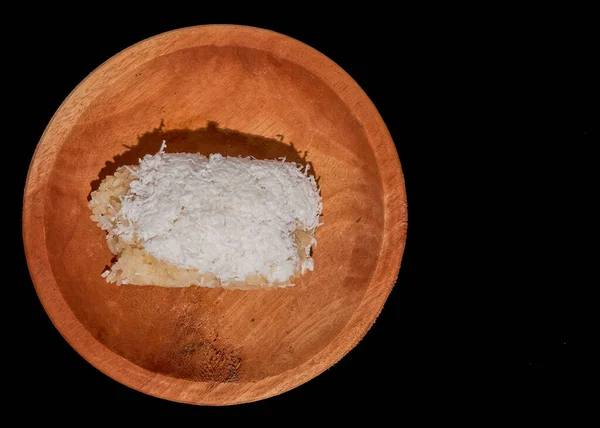 一种印尼人的食物，有粘稠的米和香蕉在木盘上，孤立的黑色背景 — 图库照片