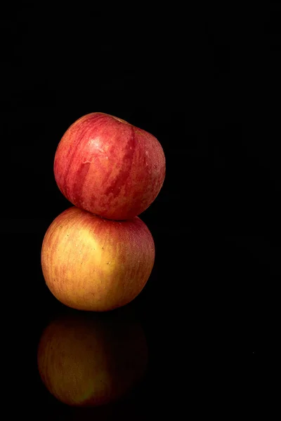 Dos manzanas dispuestas aisladas sobre fondo negro, con reflejo. - imagen — Foto de Stock