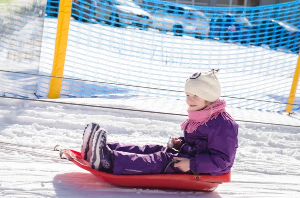Little girl in bob-sleigh enjoying winter time — Stock Photo, Image