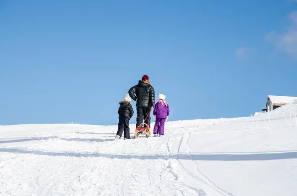 Adam kış zamanında çocuklarla — Stok fotoğraf