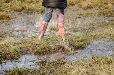 çamurlu çayırda lastik çizmeler