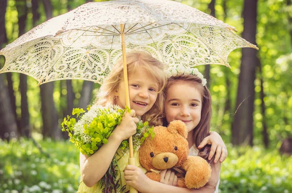 Härliga tjejer hålla nallebjörn och paraply — Stockfoto