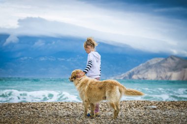 little girl with dog in the rocky beach  clipart