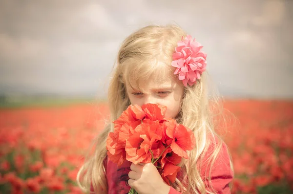 可爱的小女孩 用手中的红色罂粟花 — 图库照片