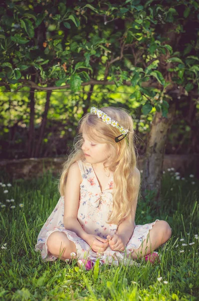 Roztomilé malé dítě sedící v trávě — Stock fotografie