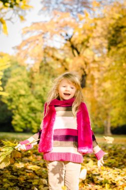 sevimli küçük sarışın kız atma renkli sonbahar parkta bırakır