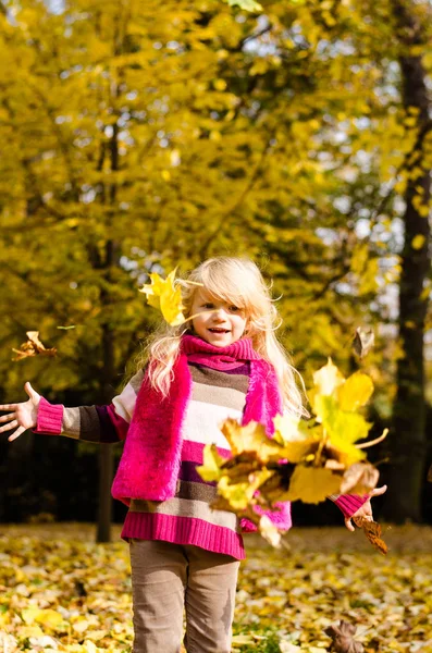 Kind gooien van kleurrijke Herfstbladeren — Stockfoto