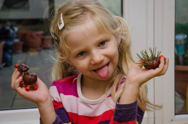 kestane meyvelerden yapılmış sonbahar dekorasyonu ile güzel çocuk