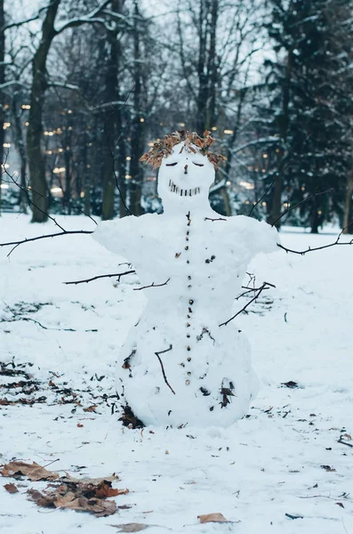 happy snowman figure smiling in winter forest