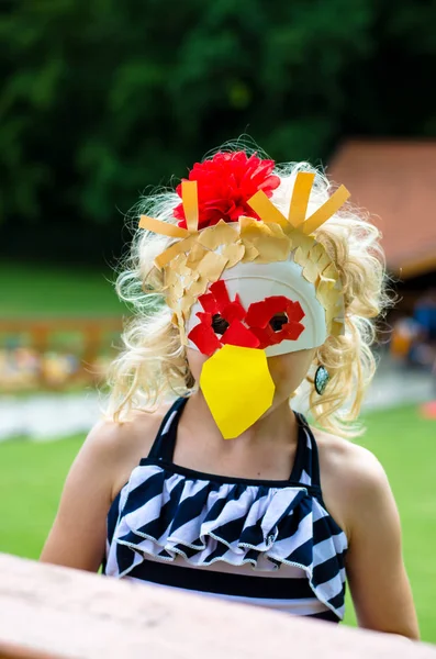 portrait of lovely blond caucasian girl with chicken mask from paper