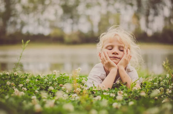 Kleines Hübsches Mädchen Mit Blonden Haaren Das Gras Fluss Liegt — Stockfoto