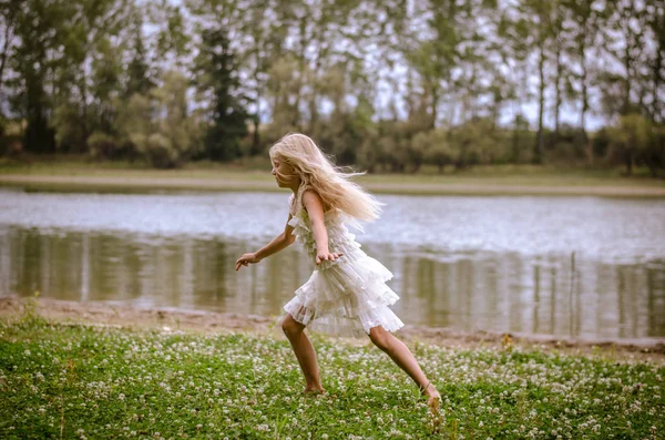 Маленька Дівчинка Довгим Світлим Волоссям Білій Сукні Біжить Біля Річки — стокове фото