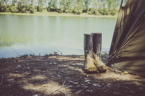 Botas sucias de pescador al lado del río — Foto de Stock