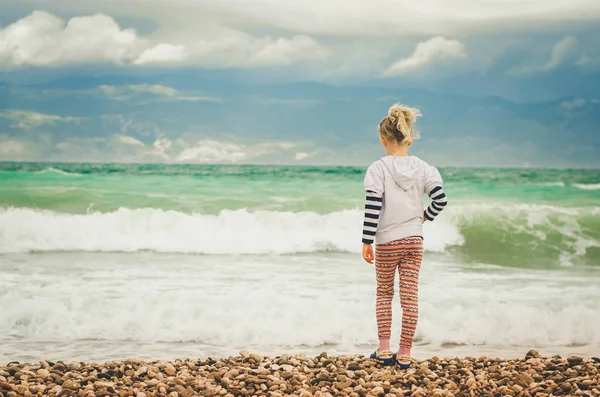 小可爱的金发女孩看着海的地平线 — 图库照片