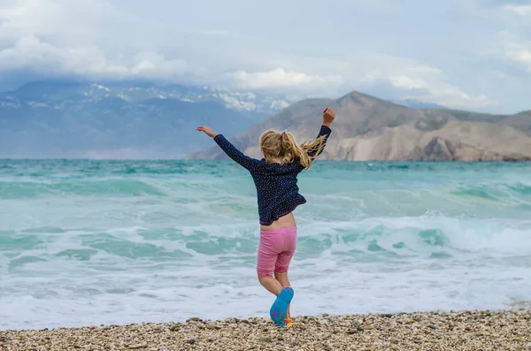 Glad Liten Rinnande Flicka Tillbaka Visa Den Steniga Stranden Med — Stockfoto