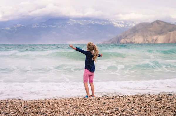 Glad Liten Rinnande Flicka Tillbaka Visa Den Steniga Stranden Med — Stockfoto