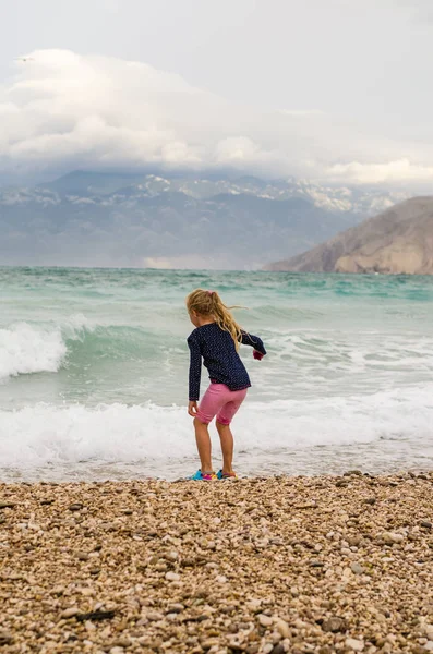 Feliz Menina Saltando Vista Volta Praia Rochosa Com Mar Pesado — Fotografia de Stock