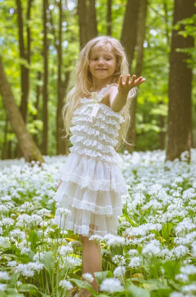 Linda menina sorridente em vestido branco na floresta de primavera — Fotografia de Stock