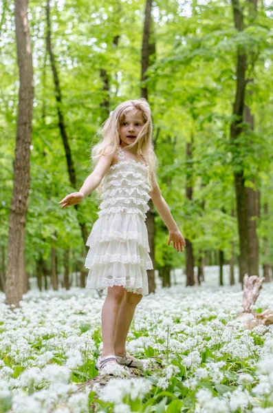 Criança em vestido branco na floresta de primavera — Fotografia de Stock