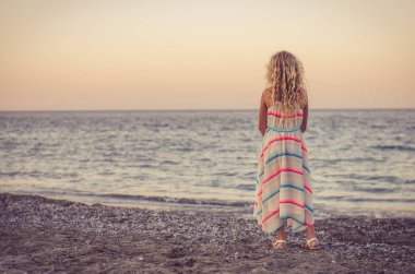 uzun sarı plajda durup ve denize bakarak ile küçük çocuk