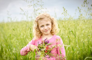 Bahar yeşil buğday alanında uzun sarı saçlı kız