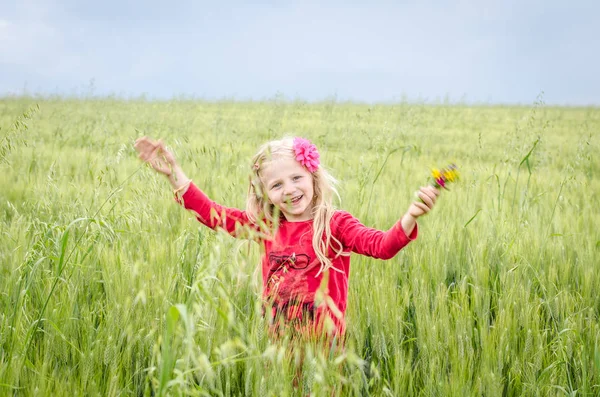 Lyckligt leende kid i fältet vete — Stockfoto