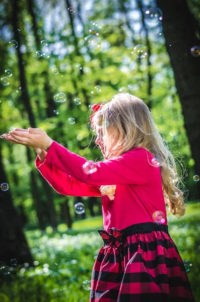 Schönes Kleines Blondes Mädchen Das Draußen Grünen Frühlingswald Mit Seifenblasen — Stockfoto