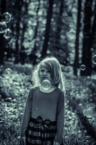 Menina triste assistindo bolhas de sabão — Fotografia de Stock