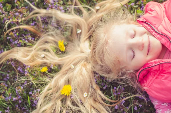 Kleines hübsches Kind mit Blumen im Haar — Stockfoto