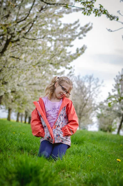 Adorável Menina Loira Sentado Grama Verde Sob Árvores Com Flores — Fotografia de Stock