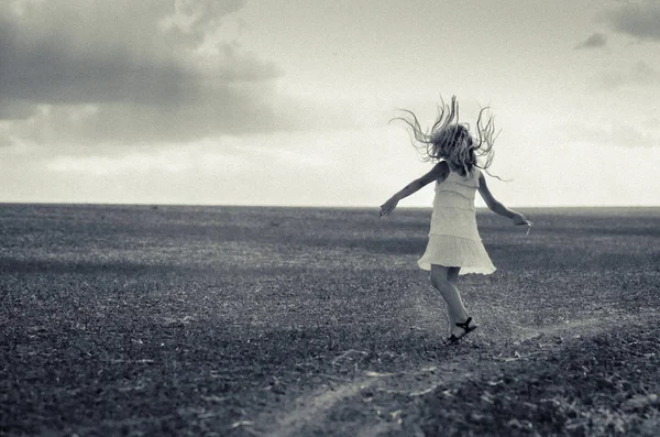 Imagem estranha de menina dançando no campo com o cabelo voando no ar — Fotografia de Stock