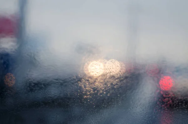 Luci sfocate auto nella strada piovosa — Foto Stock