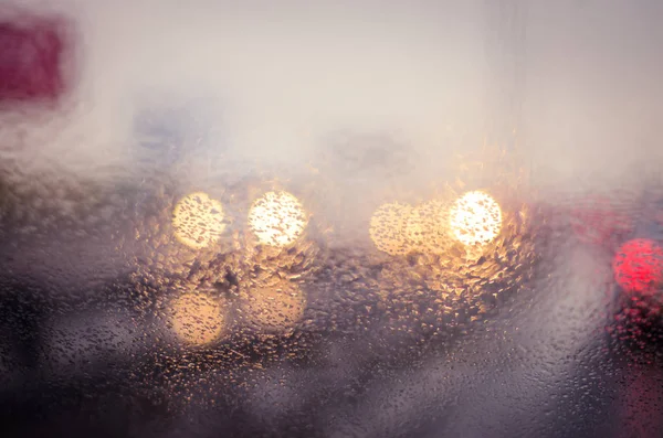Luci sfocate auto nella strada piovosa — Foto Stock