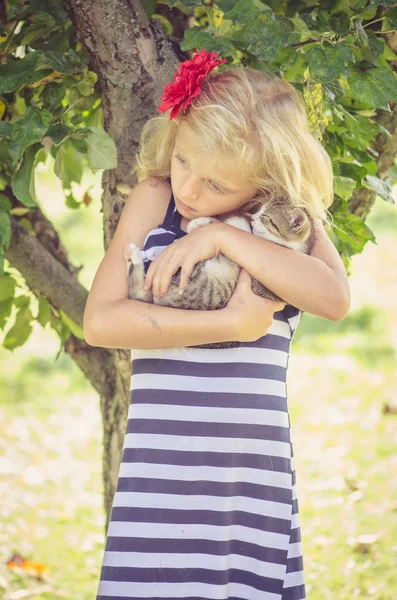 Sevimli bir kedi tutan sevimli bir çocuk. — Stok fotoğraf