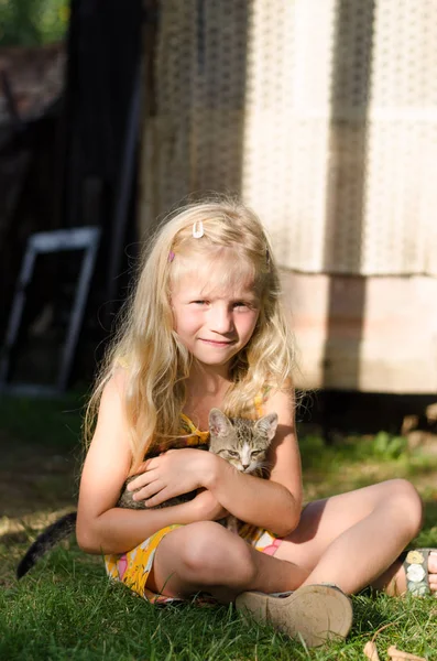 Очаровательный ребенок держит милую кошку — стоковое фото