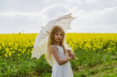 Güzel sarışın bayan beyaz güneş kremi şemsiyesiyle poz veriyor.