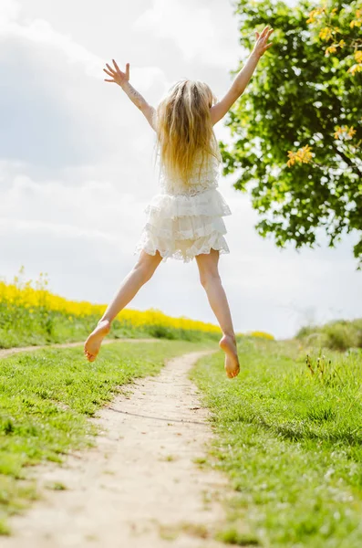 Estranho loiro menina saltando alto no ar de volta vista — Fotografia de Stock