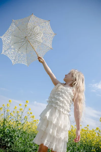 Beautiful blond girl posing with white sunshade umbrella — Stock Photo, Image